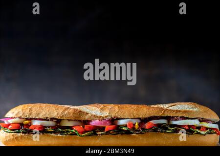 Sandwich végétarien avec courgettes grillées, œufs durs en tranches, poivrons rouges rôtis et oignons rouges marinés. Banque D'Images