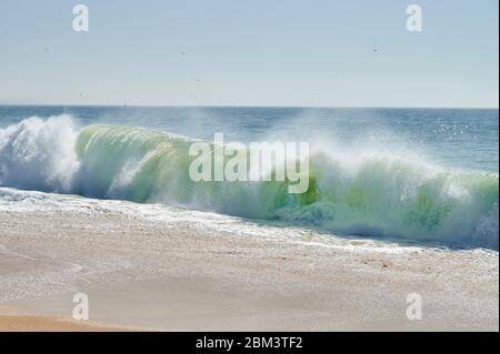 des vagues vertes de l'atlantique se brisent sur la plage du nord de la plage, Nazaré Banque D'Images