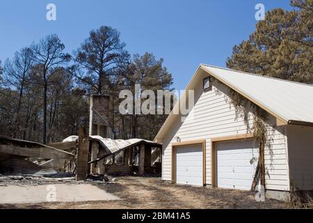 Bastrop County Texas USA, 9 septembre 2011: Un garage est intact tandis que la maison à côté de lui se trouve dans les ruines de l'autoroute 21 après un feu de forêt a traversé les forêts de piney dans le comté de Bastrop 30 miles à l'est d'Austin. Les incendies ont détruit 1 400 maisons et ont brûlé plus de 38 000 acres alors qu'il a fait rage hors de contrôle pendant cinq jours. ©Bob Daemmrich Banque D'Images