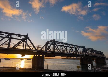Le soleil se lève à l'horizon sous le pont ferroviaire historique de Tauraga Banque D'Images