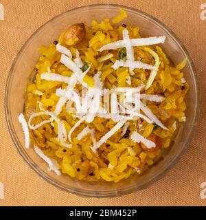 Poha plat de petit déjeuner indien sain et populaire fait avec du riz aplati servi dans un bol en verre. Banque D'Images