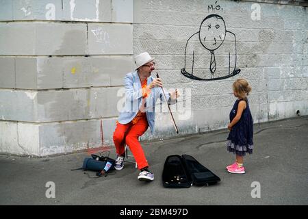 Un clown interprète de rue jouant de la musique pour une jeune fille à Montmartre.Paris.France Banque D'Images