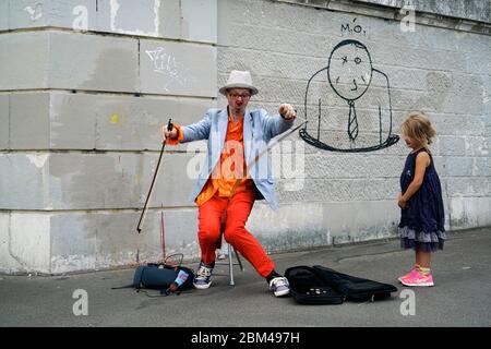 Un clown interprète de rue jouant de la musique pour une jeune fille à Montmartre.Paris.France Banque D'Images