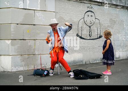 Un clown interprète de rue jouant de la musique pour une jeune fille à Montmartre.Paris.France Banque D'Images