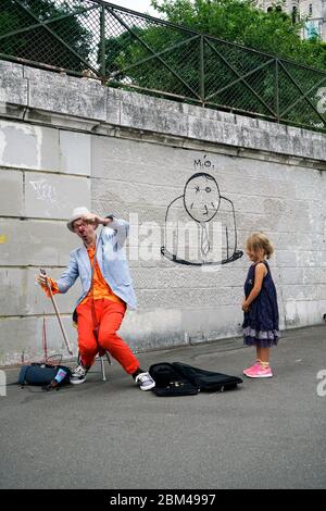 Un clown interprète de rue jouant de la musique pour une jeune fille à Montmartre.Paris.France Banque D'Images