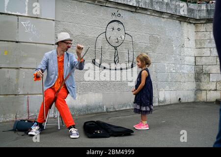 Un clown interprète de rue jouant de la musique pour une jeune fille à Montmartre.Paris.France Banque D'Images