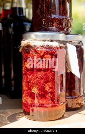 Confiture de fraises maison sur fond de bois dans un cadre extérieur, pendant le festival gastronomique. Sensation naturelle en plein soleil, sous le soleil et en été Banque D'Images