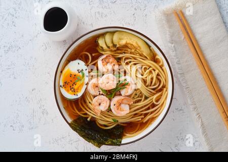 Soupe asiatique aux nouilles, ramen aux crevettes, pâte miso, sauce soja. Table en pierre blanche Banque D'Images
