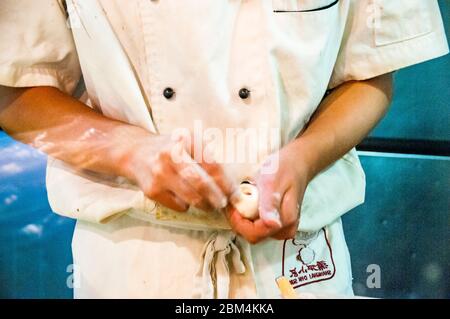 Un chef making xiaolongbao (boulettes soupe) dans un petit restaurant à Shanghai. Banque D'Images