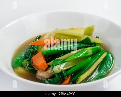 Légumes sautés avec petits pois, chou frisé et carottes sur fond blanc Banque D'Images