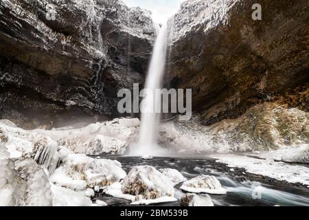 Capture à longue exposition de la cascade de Kvernufoss dans le sud de l'Islande. Cette chute spectaculaire est cachée dans la région de Skogar et est montrée ici pendant le wi Banque D'Images