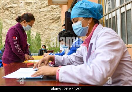 (200507) -- YECHENG, 7 mai 2020 (Xinhua) -- UN villageois parle à des médecins à la clinique du village de Yaragzi, dans le canton de Xihxu, dans le comté de Yecheng, dans la région autonome de Xinjiang Uygur, dans le nord-ouest de la Chine, le 2 mai 2020. Tôt le matin, les villageois du village de Yaragzi sont venus à la clinique locale pour des bilans de santé gratuits annuels. Outre les contrôles de santé, les villageois locaux ont également appris la politique médicale et un mode de vie sain des médecins du canton de Xihxu. Xinjiang a commencé à offrir des bilans de santé universels gratuits à partir d'octobre 2016. Les résidents urbains et ruraux de la région sont admissibles à un contrôle de santé gratuit tous les Banque D'Images