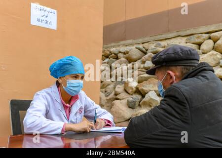 (200507) -- YECHENG, 7 mai 2020 (Xinhua) -- UN médecin enregistre les informations d'un villageois pour un bilan de santé à la clinique du village de Yaragzi, dans le canton de Xihxu, dans le comté de Yecheng, dans la région autonome de Xinjiang, dans le nord-ouest de la Chine, le 2 mai 2020. Tôt le matin, les villageois du village de Yaragzi sont venus à la clinique locale pour des bilans de santé gratuits annuels. Outre les contrôles de santé, les villageois locaux ont également appris la politique médicale et un mode de vie sain des médecins du canton de Xihxu. Xinjiang a commencé à offrir des bilans de santé universels gratuits à partir d'octobre 2016. Les résidents urbains et ruraux de la région sont e Banque D'Images