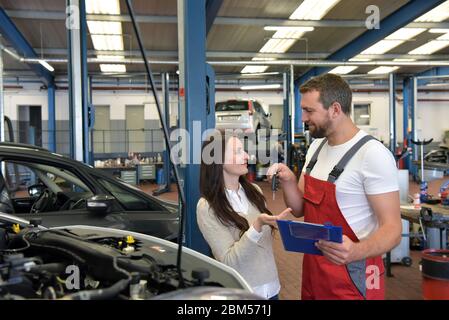 Service client : le mécanicien automobile et le client se sont remis les clés après la réparation du véhicule sur site Banque D'Images