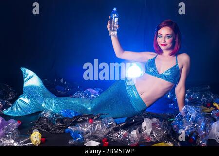 Fantasy stupide sirène dans les profondeurs de l'océan. Pollution des bouteilles et des sacs d'eau en plastique sur le fond marin. Problème environnemental. Banque D'Images