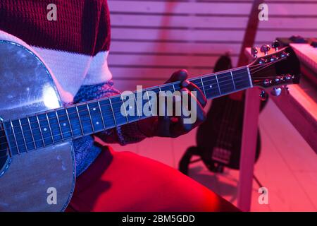 Créer de la musique et un studio d'enregistrement concept - african american man guitariste enregistrement de piste de guitare électrique dans le studio à domicile, gros plan. Banque D'Images