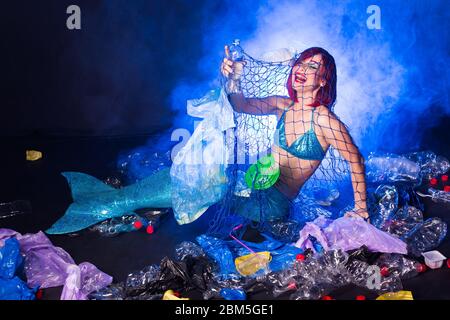 Fantasy stupide sirène dans les profondeurs de l'océan. Pollution des bouteilles et des sacs d'eau en plastique sur le fond marin. Problème environnemental. Banque D'Images