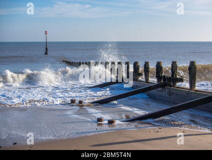 Une gémissement en bois à Hornsea Beach avec de petites vagues et un ciel bleu Banque D'Images