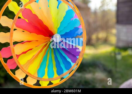 Roue d'épingle colorée tournant dans le vent devant un fond vert naturel.Focus sur le centre de la roue d'épingle.jouet coloré. Liberté et drôle de concept.Toy Banque D'Images