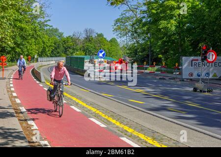 Cyclistes sur piste cyclable passant devant les travaux routiers effectués à Mariakerkebrug, pont des années 60 dans le village Mariakerke près de Gand, Flandre orientale, Belgique Banque D'Images