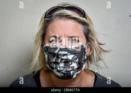 L'artiste Shelley Dyer Gibbins, 47 ans, du village de Croscombe, près de Wells, Somerset, porte un masque chirurgical recouvert d'un imprimé cinégirl, réalisé par elle-même, et a fait des masques faciaux de designer pour les 600 résidents à partir de matériel de masque de qualité médicale et certains de son art imprimé qu'elle avait laissé. Banque D'Images