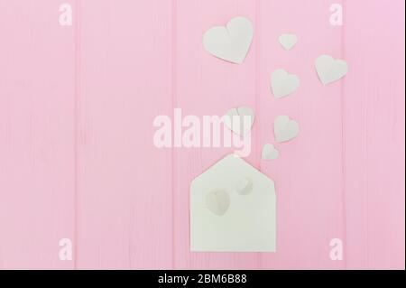 Carte de voeux de Saint-Valentin enveloppe avec coeurs. Les coeurs blancs sont en arrière-plan sur fond de bois rose. Copier l'espace. Les cœurs sortent Banque D'Images