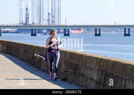 Dundee, Tayside, Écosse, Royaume-Uni. 7 mai 2020. Météo au Royaume-Uni : une matinée chaude et ensoleillée à Dundee avec des températures atteignant 19°C. Une jeune fille aux courbes qui profite du temps glorieux tout en faisant des exercices en plein air, qui fait du jogging le long de la promenade du bord de mer pendant les restrictions de maintien de Covid-19. Crédit : Dundee Photographics/Alamy Live News Banque D'Images