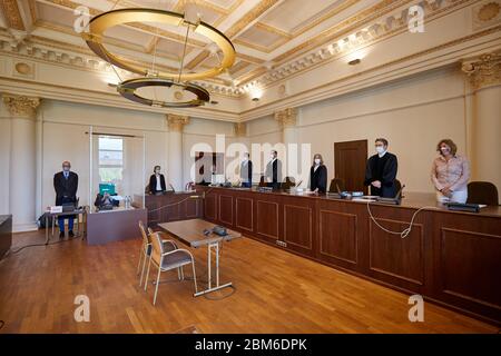 07 mai 2020, Hambourg: Au début d'une autre journée de procès, l'ancien garde SS accusé de 93 ans est assis dans la salle d'audience du tribunal régional et couvre son visage avec un dossier, tandis que se trouve à côté de lui son avocat Stefan Waterkamp (l), un médecin (3e de gauche), Anne Maier-Göring (3e de droite), présidente du tribunal et autres participants au procès. Pour protéger le défendeur contre le virus corona, il participera derrière un bouclier en plexiglas. Selon le bureau du procureur, le défendeur, qui vit à Hambourg, était un jeune homme qui a été déployé dans la came de concentration Stustthof Banque D'Images