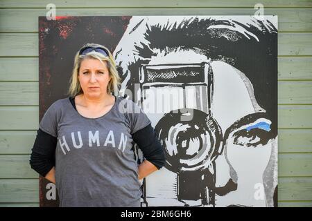 L'artiste Shelley Dyer Gibbins, 47 ans, du village de Croscombe, près de Wells, est assis près de l'une de ses œuvres intitulées Cinegirl, Elle a utilisé pour créer des masques faciaux de designer pour les 600 résidents du village Somerset, à partir de masques de qualité médicale et de certains de ses imprimés artistiques qu'elle avait laissés. Banque D'Images