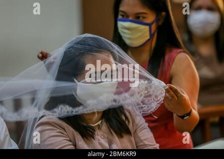 Quezon City, Philippines. 7 mai 2020. Une invitée aide une mariée avec son voile lors d'une cérémonie de mariage à Quezon City, aux Philippines, le 7 mai 2020. Les Philippines ont signalé jeudi 339 nouveaux cas de COVID-19, portant le nombre total des cas de COVID-19 dans le pays à 10,343. Crédit: Rouelle Umali/Xinhua/Alay Live News Banque D'Images