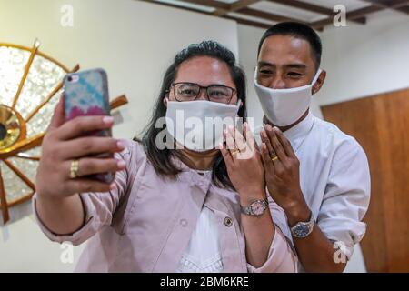 Quezon City, Philippines. 7 mai 2020. Un couple nouvellement-mer montre leurs anneaux de mariage à des amis par un appel vidéo lors d'une cérémonie de mariage à Quezon City, aux Philippines, le 7 mai 2020. Les Philippines ont signalé jeudi 339 nouveaux cas de COVID-19, portant le nombre total des cas de COVID-19 dans le pays à 10,343. Crédit: Rouelle Umali/Xinhua/Alay Live News Banque D'Images