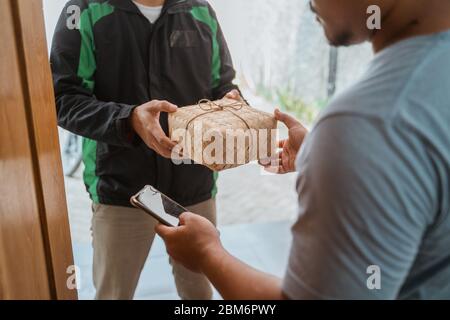 Liveur de la nourriture à un homme à la maison - concept de service d'achat de nourriture en ligne Banque D'Images