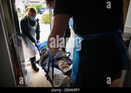 NOTE DE LA RÉDACTION : le patient a donné son consentement pour être photographié. Une équipe d'ambulance portant des vêtements de protection transporte une patiente dont l'état n'était pas lié à Covid-19, de son domicile dans une Sling de Southampton après avoir répondu à un appel de 999 à Portsmouth, Hampshire. Banque D'Images
