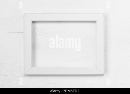 Cadre blanc sur fond blanc en bois. Vue de dessus. Copier l'espace. Pose à plat. Concept minimal. Banque D'Images