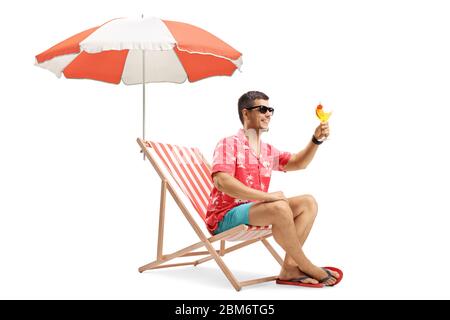 Jeune homme qui fait un toast avec un cocktail sous un parapluie isolé sur fond blanc Banque D'Images