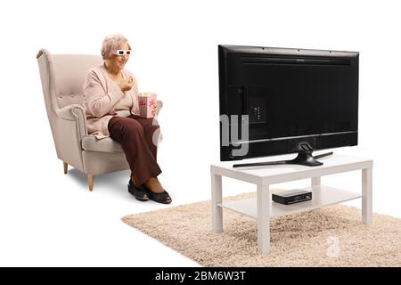 Femme âgée qui mange du pop-corn et qui regarde un film en 3d à la maison Banque D'Images