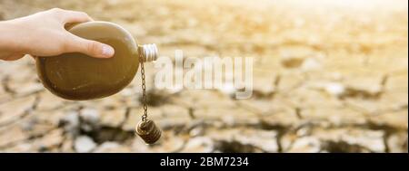 Homme avec une fiole dans le désert. Sécheresse et pénurie d'eau causées par le réchauffement climatique Banque D'Images