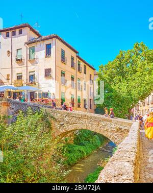 GRENADE, ESPAGNE - 25 SEPTEMBRE 2019 : les touristes marchent le pont en pierre médiéval Puente de Cabrera au-dessus du fleuve Darro, traversant la gorge de Carrera del Banque D'Images