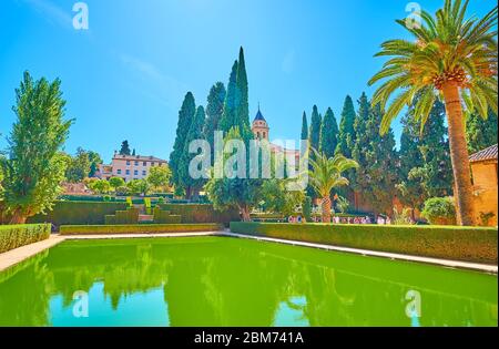 GRENADE, ESPAGNE - 25 SEPTEMBRE 2019 : la piscine, entourée d'un jardin pittoresque de la Partal, de massifs fleuris et de grands thuyas, Alhambra, le 25 septembre Banque D'Images