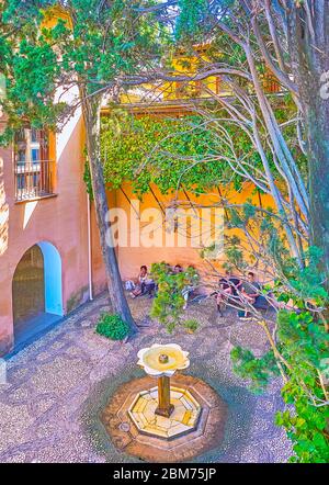 GRENADE, ESPAGNE - 25 SEPTEMBRE 2019 : le petit patio de la grille en fer forgé (palais Nasrid, Alhambra) avec motif géométrique de galets sur le sol A. Banque D'Images