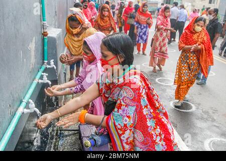 Dhaka, Bangladesh. 7 mai 2020. Les travailleurs se lavent les mains avant d'entrer dans une usine de vêtements à Dhaka, au Bangladesh, le 7 mai 2020. Des milliers d'usines de vêtements readymade (RMG) au Bangladesh ont repris leurs activités depuis la semaine dernière à une échelle limitée. Crédit: STR/Xinhua/Alay Live News Banque D'Images