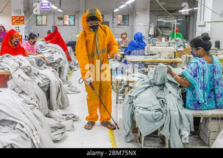 Dhaka, Bangladesh. 7 mai 2020. Un travailleur vaporise du désinfectant dans une usine de vêtements à Dhaka, au Bangladesh, le 7 mai 2020. Des milliers d'usines de vêtements readymade (RMG) au Bangladesh ont repris leurs activités depuis la semaine dernière à une échelle limitée. Crédit: STR/Xinhua/Alay Live News Banque D'Images