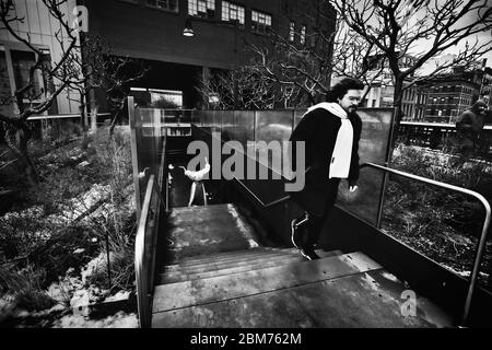 Photographie de rue sur la High Line, un parc public moderne construit sur une ligne de train de marchandises historique, au-dessus des rues du côté ouest de Manhattan. Banque D'Images