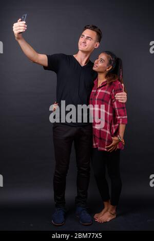 Portrait d'un jeune heureux couple multiethnique prenant le selfie ensemble Banque D'Images