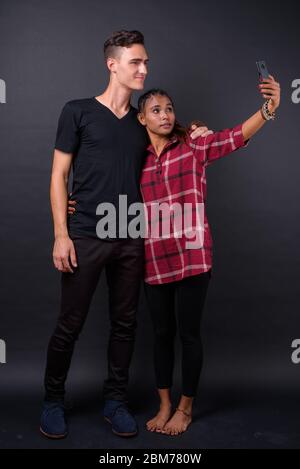 Portrait d'un jeune heureux couple multiethnique prenant le selfie ensemble Banque D'Images