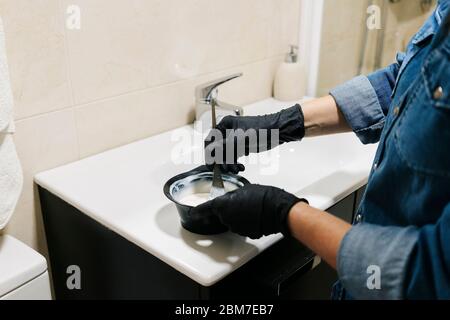 Une femme teint ses cheveux à la maison. Banque D'Images