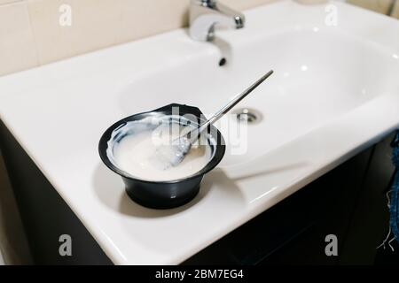 Une femme teint ses cheveux à la maison. Banque D'Images