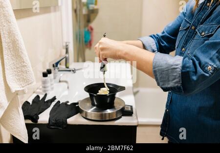 Une femme teint ses cheveux à la maison. Banque D'Images