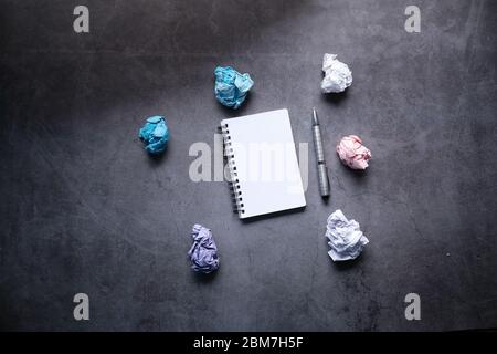 Vue de dessus des boules de papier froissés et du bloc-notes sur fond gris. Banque D'Images