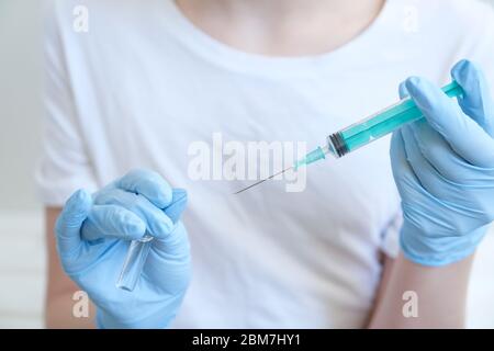 Personne dans un gant bleu tenir le flacon de vaccin avec une seringue. Concept de pharmacie d'injection. Infirmière-thérapie médicale. Maquette, espace de copie Banque D'Images